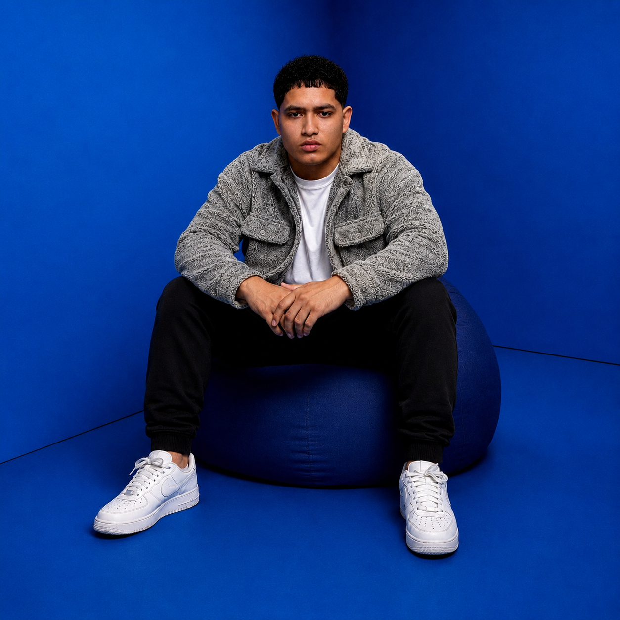 Retrato del artista sentado frente a un fondo azul